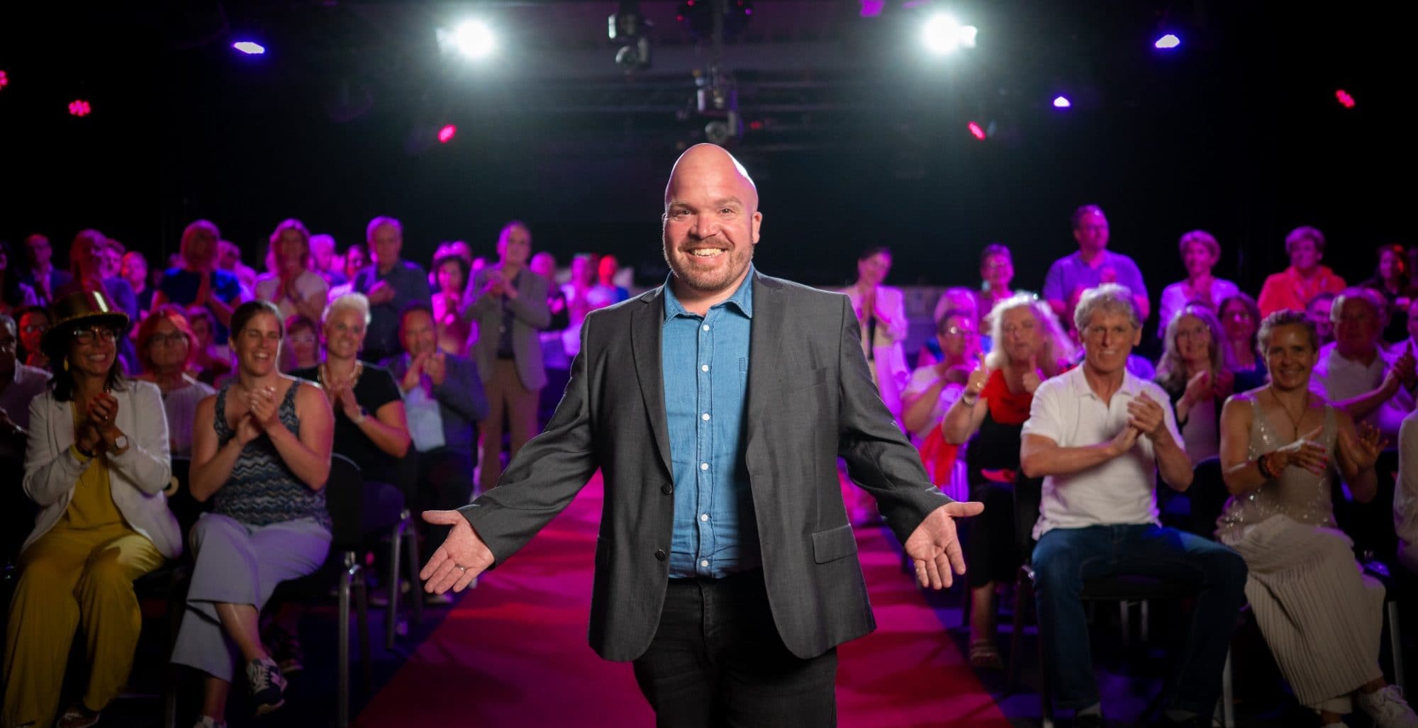 Mirko Kühner auf der Bühne vor applaudierendem Publikum
